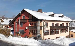 een gebouw met sneeuw erop bij Hotel Waldfrieden "Das kleine Hotel" in Spiegelau