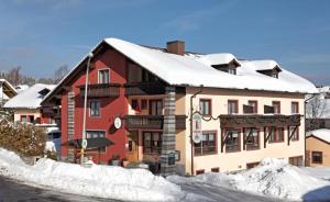 ein Gebäude mit Schnee drauf in der Unterkunft Hotel Waldfrieden "Das kleine Hotel" in Spiegelau