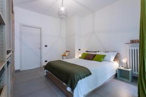 una camera bianca con un grande letto con cuscini verdi di Casa Foà con terrazzo a due passi dal Parco by Wonderful Italy a Torino