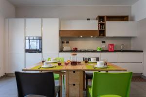 una cucina con tavolo in legno e sedie verdi di Casa Foà con terrazzo a due passi dal Parco by Wonderful Italy a Torino