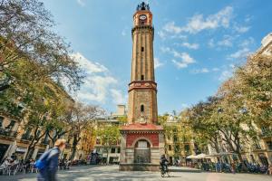 a tall clock tower in the middle of a street at Gracia Apartment in Barcelona