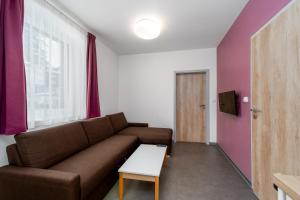 a living room with a brown couch and a table at Pension Janský Potok II. in Janske Lazne