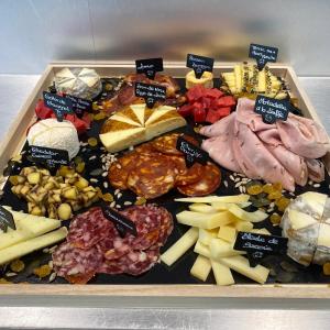 a tray filled with different types of cheese and meats at Le Sorbier, Style Appart'Hôtel, vers la gare, by PRIMO C0NCIERGERIE in Nevers