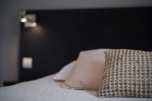 a close up of a bed with a pillow on it at Hôtel - Restaurant U Santu Petru in Saint-Florent