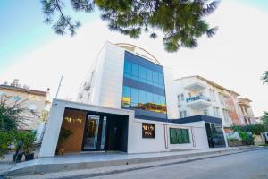 a white building with blue windows on a street at Moon suites in Antalya