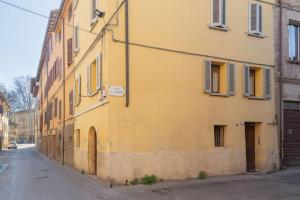 żółty budynek po stronie ulicy w obiekcie Guest House San Pietro w mieście Reggio nell'Emilia