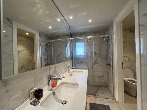 uma casa de banho branca com um lavatório e um espelho em Central Business Suites Nicosia By Platform 357 em Nicósia