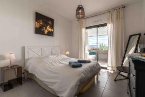 sypialnia z dużym białym łóżkiem i oknem w obiekcie Ajaccio, les Cyclades, magnifique appartement vue mer w Ajaccio