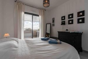 sypialnia z dużym białym łóżkiem i oknem w obiekcie Ajaccio, les Cyclades, magnifique appartement vue mer w Ajaccio