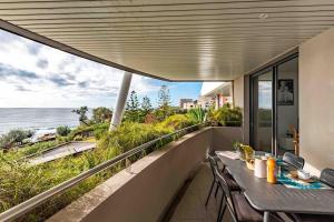 balkon ze stołem i krzesłami oraz oceanem w obiekcie Ajaccio, les Cyclades, magnifique appartement vue mer w Ajaccio