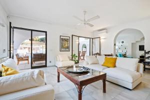 a living room with white furniture and a table at Villa Sahara in Marbella