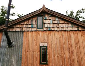 un edificio de madera con ventana y techo en Cabin Westerlands en Selham