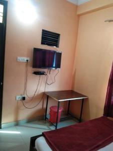 a room with a desk and a tv on the wall at Hotel Hansa Palace by WB Inn in Kānpur