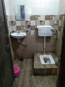 a bathroom with a toilet and a sink at Hotel Hansa Palace by WB Inn in Kānpur