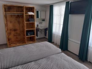 a bedroom with a bed and a cabinet and a window at Gasthof Schnittweierbad in Steffisburg