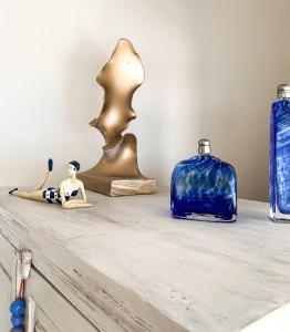 uma prateleira com estatuetas com vasos azuis e dourados em La Pausa em Porto Heli