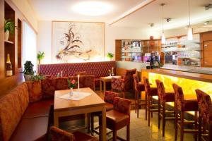 ein Restaurant mit Sofa und Tischen und eine Bar in der Unterkunft Schillerhof Hotel GARNI in Vöcklabruck
