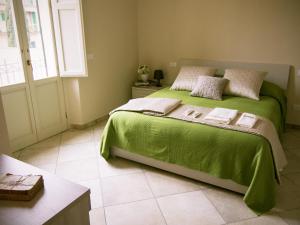 a bedroom with a green bed and a window at Zula Affittacamere in Florence