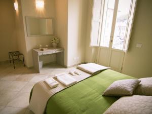 Un dormitorio con una cama verde con toallas. en Zula Affittacamere, en Florencia