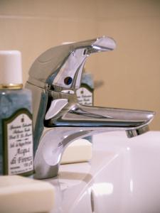 a silver faucet on a sink with a bottle of soap at Zula Affittacamere in Florence