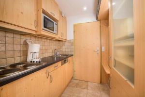 a small kitchen with wooden cabinets and a sink at Appartement Wiesberger 62 Top 6 in Königsleiten