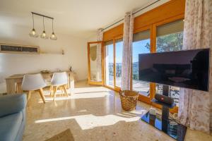 sala de estar con TV de pantalla plana grande en HomeHolidaysRentals Dorada - Costa Barcelona, en Palafolls