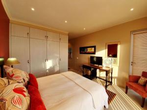 1 dormitorio con 1 cama y escritorio con ordenador en Luxury Villa in Pinnacle Point with Inverter en Mossel Bay