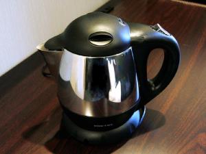 a black and silver tea kettle sitting on a table at HOTEL LiVEMAX BUDGET Higashi Ueno in Tokyo