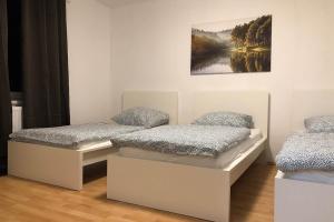 dwa łóżka w pokoju z obrazem na ścianie w obiekcie cozy Apartments with WiFi w mieście Oberhausen