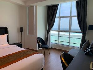 a hotel room with a bed and a large window at Rivethi Beach in Hulhumale