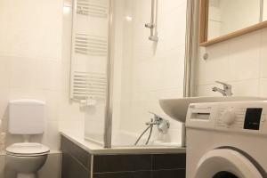 a bathroom with a toilet and a sink and a washing machine at cozy Apartments with WiFi in Oberhausen