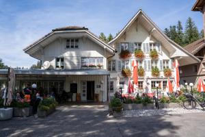 Ein Haus mit Leuten, die draußen sitzen. in der Unterkunft Gasthof Schnittweierbad in Steffisburg