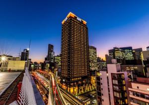 un profilo della città con un edificio alto e traffico di APA Hotel & Resort Osaka Umeda Eki Tower ad Osaka