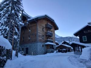 a large wooden building with snow on the ground at Auberge RDC in Morzine