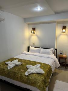 a bedroom with a large bed with towels on it at BB House Budget & Boutique in Chiang Mai