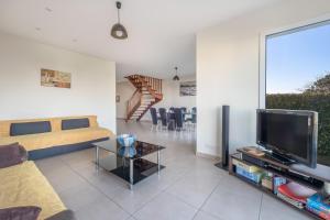 a living room with a couch and a tv at Maison lumineuse, pour 8, avec vue sur mer in Saint-Gildas-de-Rhuys