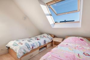 um quarto com 2 camas e uma janela em Maison lumineuse, pour 8, avec vue sur mer em Saint-Gildas-de-Rhuys
