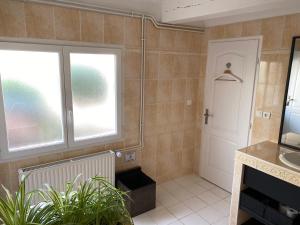uma casa de banho com um lavatório e uma janela em Le Beauvaisis em Esches