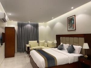 1 dormitorio con 1 cama grande y 1 sofá en فندق الأفنيوز بالرس en Al Rass