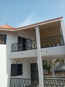 - un bâtiment blanc avec des balcons sur le côté dans l'établissement BELLE VILLA PROCHE BORD DE MER, à Ngaparou