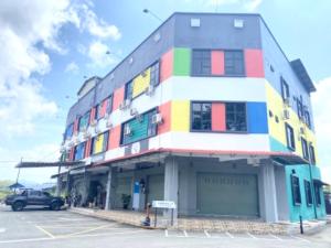 een kleurrijk gebouw met een auto geparkeerd op een parkeerplaats bij SY JERANTUT HOTEL in Jerantut