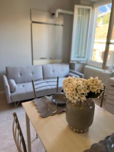 una mesa con un jarrón de flores encima en Apartment Nicole en Menaggio