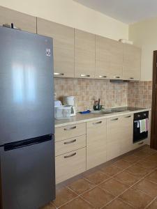 a kitchen with a stainless steel refrigerator and cabinets at Luna Bay in Agios Ioannis Pelio