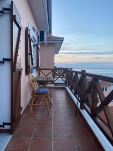 a balcony with a chair and a view of the ocean at Luna Bay in Agios Ioannis Pelio