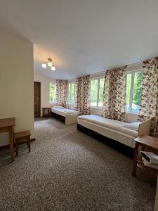 a large room with two beds and two windows at Motel Oson in Chichkan Gorge, Toktogul, Kyrgyzstan, Мотель Осон в ущелье Чычкан, Токтогул, Кыргызстан in Dzhenish