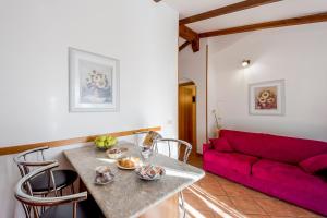 uma sala de estar com uma mesa e um sofá vermelho em Agriturismo Le Mimose em Imperia