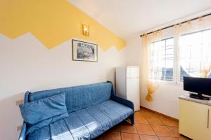 a living room with a blue couch and a tv at Agriturismo Le Mimose in Imperia