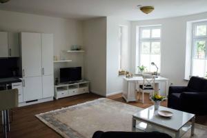 uma sala de estar com um sofá e uma mesa em Villa Schönfeld Wohnung 1 em Papenburg