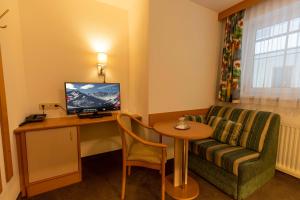 a living room with a couch and a table and a television at Gidis Hof in Ischgl