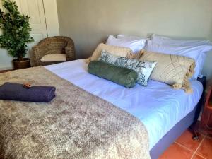 uma cama com almofadas num quarto em The Fellows Guest Accommodation em Postmasburg